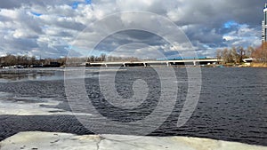 Winter Kyiv metro bridge in the sunny cloudy day with ice on the river