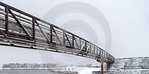 Winter lake scene with snowy bridge in Daybreak