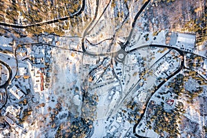 Winter landscape from the air, many winding mountain roads. Winter forest from above and Karpacz village in Poland. Winter