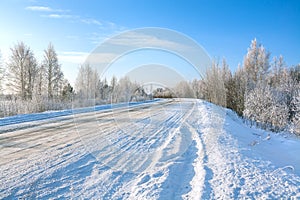 Winter landscape with asphalt road,forest and blue sky.