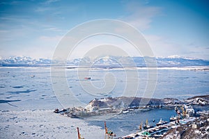 Winter landscape of the Avacha bay. Docks in Petropavlovsk city around showy mountains. Kamchatka peninsula