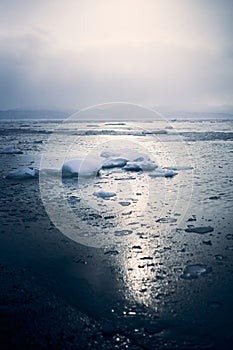 Winter landscape of the Avacha bay. Snowy mountains and ocean with ice floes at snowy weather. Kamchatka peninsula