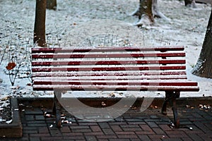 winter landscape with a bench in the first snow in the city park russia