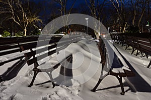 Winter landscape from Burgas Sea Garden, near the Culture center Sea Casino at blue hour, Bulgaria. Benches covered with snow