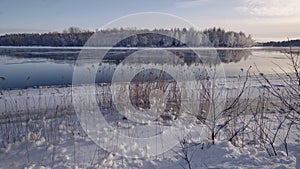 Winter landscape: the Burnaya river flows into Lake Ladoga, trees covered with hoarfrost, panoramic view