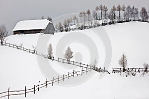 Winter landscape with cottage above the hill