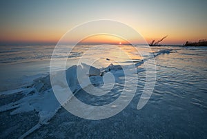 Winter landscape with cracks on the frozen lake