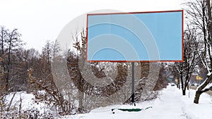 an empty billboard (template) between the road and trees