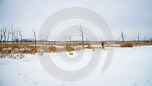 Winter landscape, Fisherman is walking on lake at winter, ice fishing