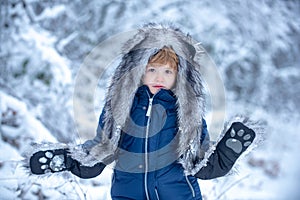 Winter landscape of forest and snow with cute child boy. Children run on snowy field. Boy dreams of winter time. Happy