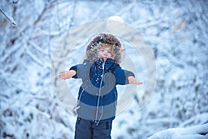 Winter landscape of forest and snow with cute child boy. Enjoying nature wintertime. Happy winter time. Well dressed