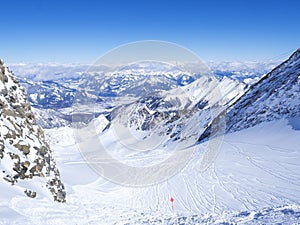 Winter landscape with free ride piste and view on snow covered slopes and blue sky, with Aerial view of Zell am See lake