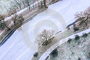 Winter landscape with frozen river and trees covered white snow. aerial photo