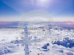Winter Landscape of frozen worship cross mountain with blue sky Kemerovo region Russia sun light, aerial top view