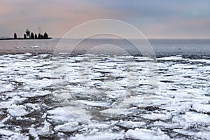 Winter landscape of icy lake with textured broken ice pieces. Frosty nature in Christmas time