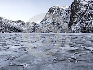 Winter landscape on a lake during Lofoten winter. Snow and ice melting