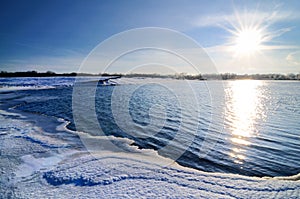 Winter landscape, lake shore covered with snow