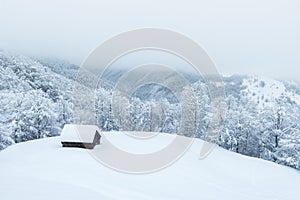 Winter landscape with lonely snowy house in the mountains