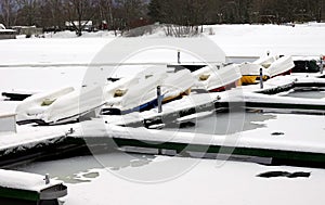 WInter landscape with many overturned boats in the snow on a dock on a frozen river in no season
