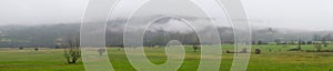 Winter Landscape Meadow and mountain in the background with low clouds