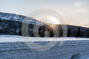 Winter landscape of a mountain forest covered with snow at sunrise