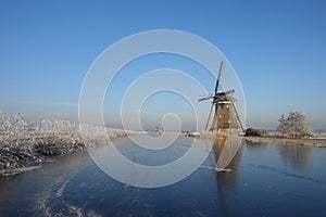Winter landscape in the Netherlands with windmill and ice
