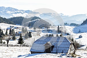 Winter landscape with and old house on the top of the mountain.