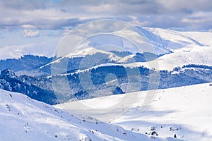 Winter landscape over Carpathian Mountains. Panorama of snow mountain range landscape with blue sky and white clouds from