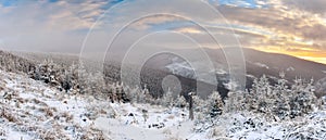 Winter landscape in the Polish mountains of the Sudetes, the view from the Marianskie Skaly summit to the snow-capped mountain