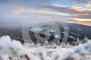 Winter landscape in the Polish mountains of the Sudetes, the view from the Marianskie Skaly summit to the snow-capped mountain