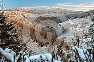 Winter landscape in the Polish mountains of the Sudetes, a view of the snow-capped mountain valley under the Snieznik peak