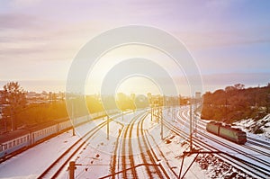 Winter landscape with a railway train on a railway surrounded by a city panorama with lots of houses and buildings against a clou