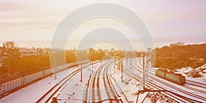 Winter landscape with a railway train on a railway surrounded by a city panorama with lots of houses and buildings against a clou