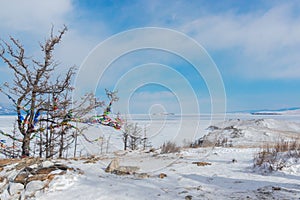 Winter landscape. A ritual site at the top of Ogoy Island. View of the mountains and frozen Lake Baikal on a winter day