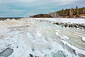 Winter landscape with a river covered with snow and ice hummocks. Western Siberia