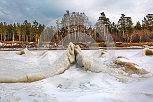 Winter landscape with a river covered with snow and ice hummocks. Western Siberia