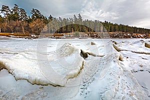 Winter landscape with a river covered with snow and ice hummocks. Western Siberia