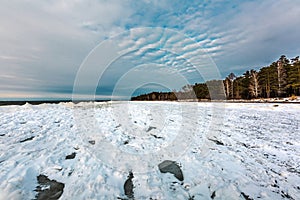 Winter landscape with a river covered with snow and ice hummocks. Western Siberia