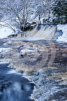 Winter landscape, river under the ice and snow, and tree branches covered with white frost