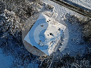 winter landscape with the ruined construction of family house. tree torso shelling