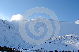 Hřeben Vysokých Tater. Slovensko. Panorama zatažené modré zimní oblohy nad zasněženými štíty Vysokých Tater.