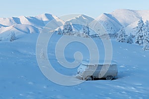 Winter landscape with a snow-covered car standing among the mountains in Yakutia, Sakha Republic