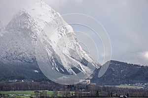 Winter landscape with snow covered Grimming mountain and Trautenfels Castle in the district of Liezen in Styria, Austria