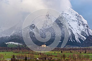 Winter landscape with snow covered Grimming mountain and Trautenfels Castle in Ennstal, Steiermark, Austria