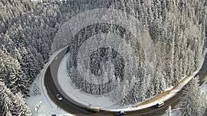 Winter landscape with snow covered mountain woods and winding forest slippery road