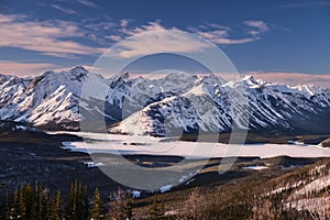 Winter landscape with snow covered mountains and frozen lake.