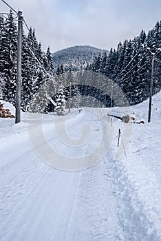 winter landscape with snow covered road, forest and hill on the background in Beskids mountains