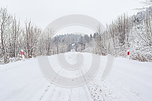 Winter landscape with snow-covered trees on the mountain road. Sudetes covered with white snow