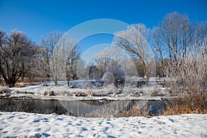 winter landscape of snow-covered trees and river in winter season, Germany