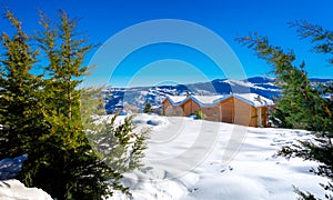 Winter landscape with snow, wooden houses and clear blue sky, Trikala Korinthias.